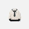 Front view of the apricot Preppy Tie Sweater in a gray background